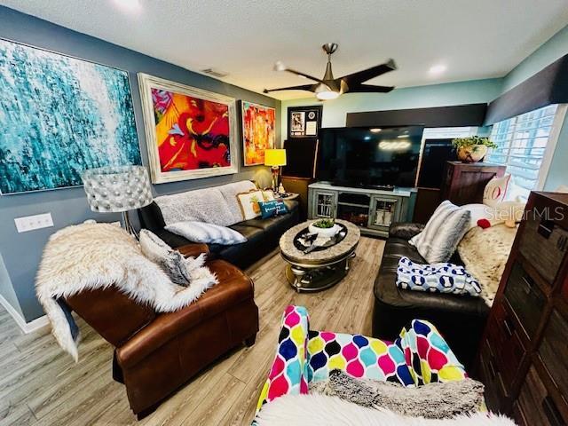 living room with ceiling fan and light wood-type flooring