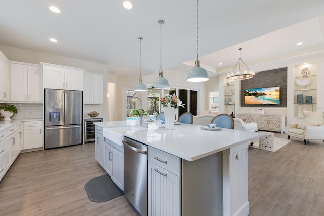 kitchen with white cabinets, sink, an island with sink, and appliances with stainless steel finishes