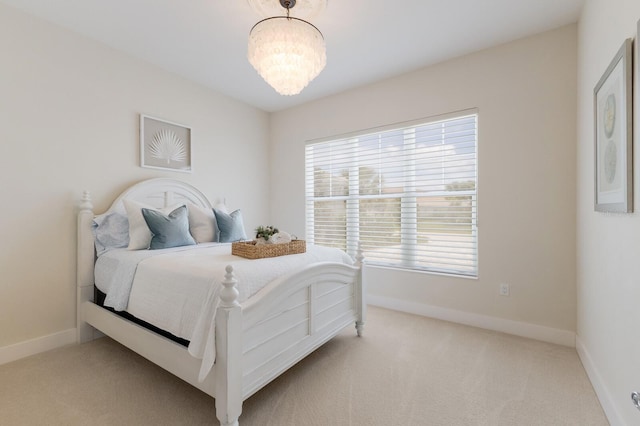 bedroom with light carpet and a chandelier