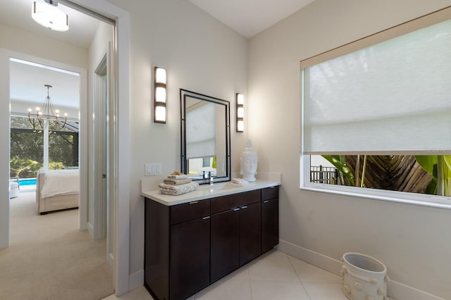 bathroom featuring tile patterned floors, vanity, a healthy amount of sunlight, and an inviting chandelier