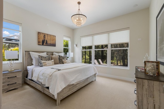 carpeted bedroom with a chandelier and multiple windows