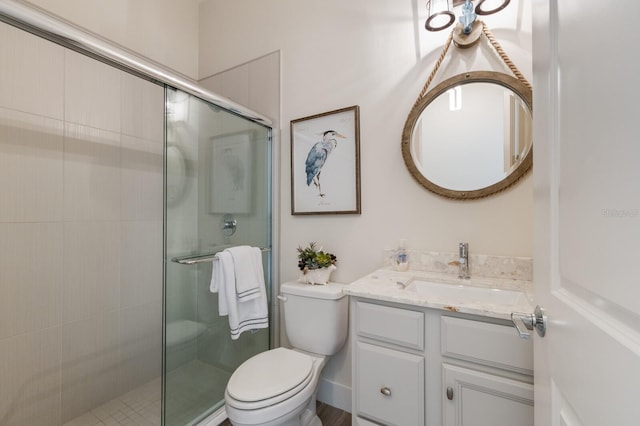 bathroom featuring vanity, toilet, and a shower with shower door