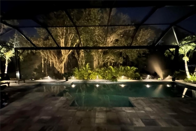 pool at twilight with a lanai and a patio