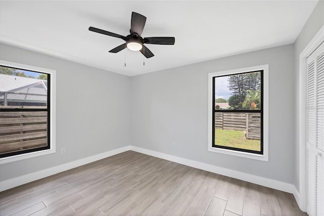 unfurnished room featuring baseboards and a wealth of natural light