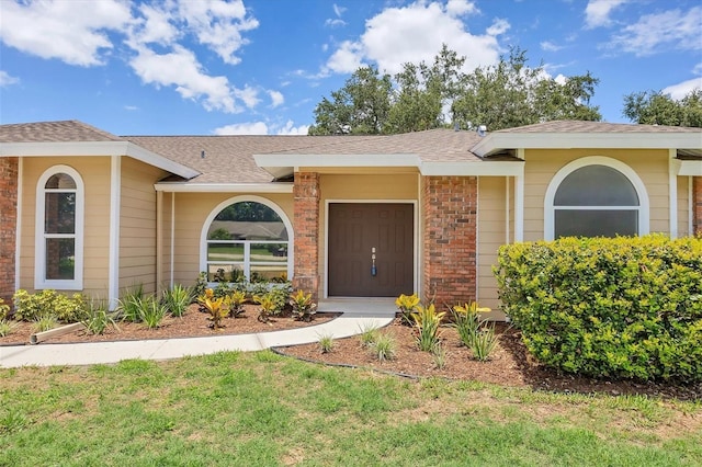 doorway to property with a lawn