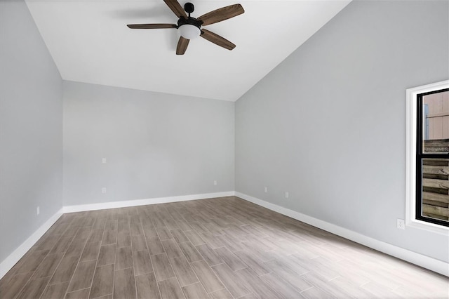 empty room featuring lofted ceiling, baseboards, a ceiling fan, and light wood-style floors