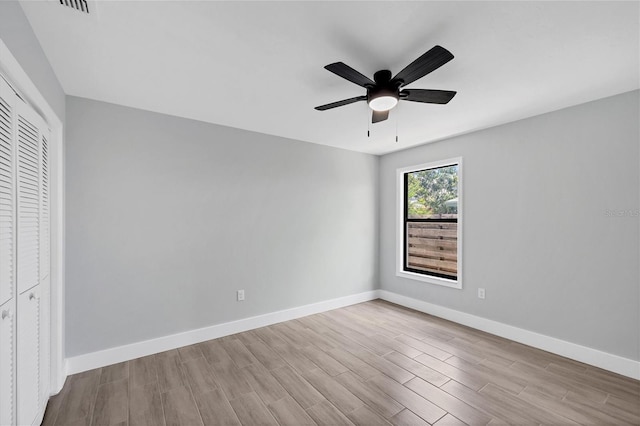 unfurnished bedroom featuring a closet, baseboards, ceiling fan, and light wood finished floors