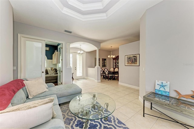 living room featuring ornate columns, crown molding, light tile patterned flooring, and an inviting chandelier