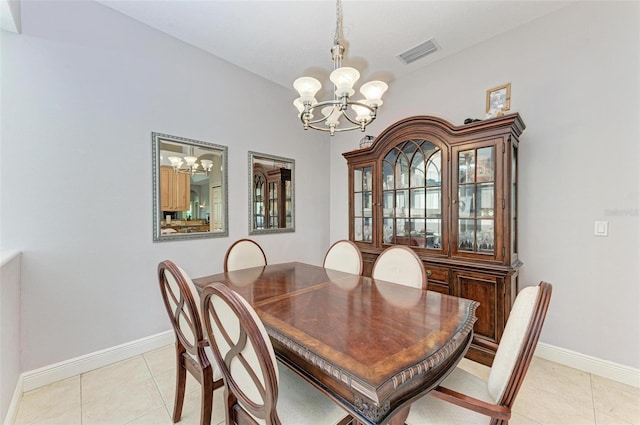 tiled dining room featuring a chandelier