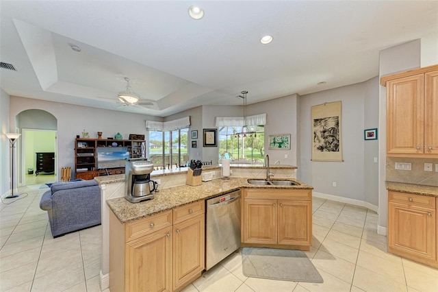 kitchen with dishwasher, a raised ceiling, sink, light tile patterned flooring, and light stone counters