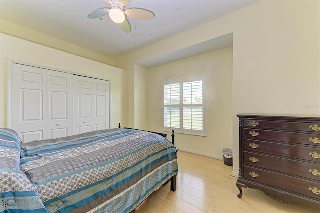 bedroom with ceiling fan, a closet, and light hardwood / wood-style floors