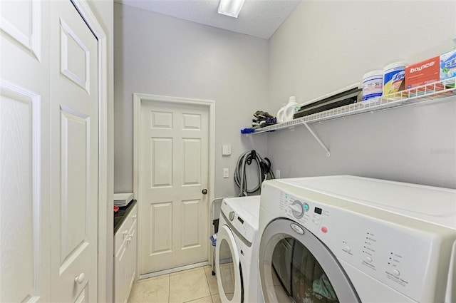 laundry area featuring cabinets, independent washer and dryer, and light tile patterned floors