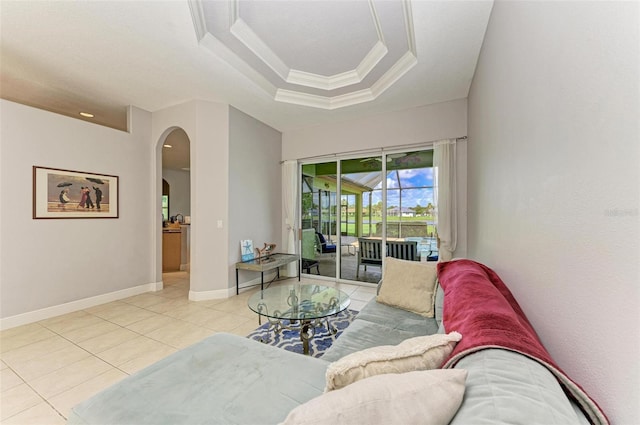 living room featuring light tile patterned floors, a raised ceiling, and crown molding