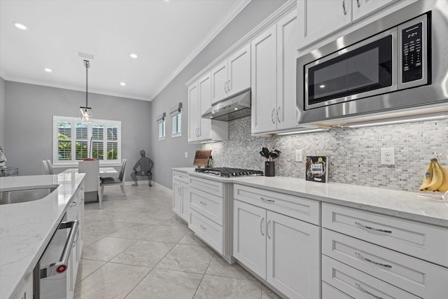 kitchen with light stone counters, white cabinetry, stainless steel appliances, and hanging light fixtures