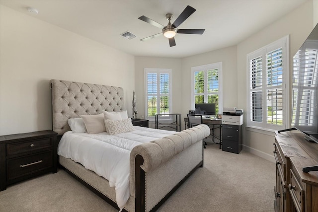 carpeted bedroom featuring multiple windows and ceiling fan