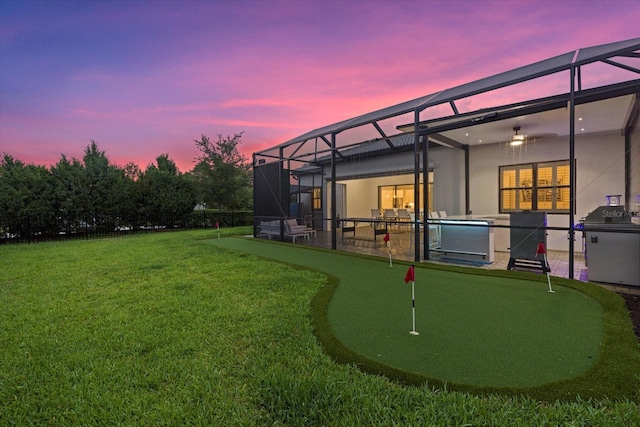 yard at dusk featuring a lanai