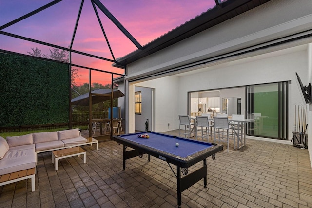 patio terrace at dusk with a lanai and an outdoor living space