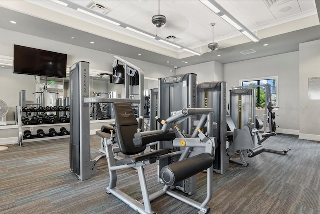 gym featuring carpet flooring, a raised ceiling, and ceiling fan