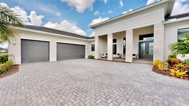 view of front of property featuring french doors, a garage, and a porch