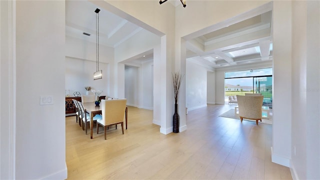 dining area with a towering ceiling, light wood-type flooring, coffered ceiling, beamed ceiling, and a chandelier