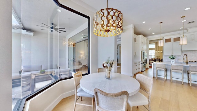 dining room featuring light hardwood / wood-style flooring, ceiling fan, and ornamental molding