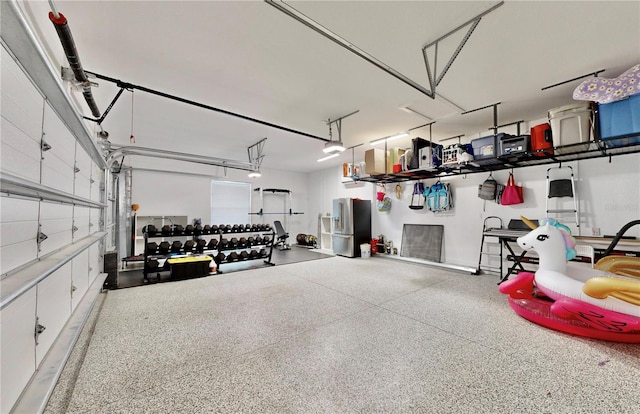 garage with stainless steel fridge and a garage door opener