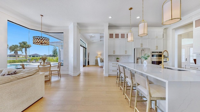 kitchen featuring white cabinets, decorative light fixtures, sink, and stainless steel appliances