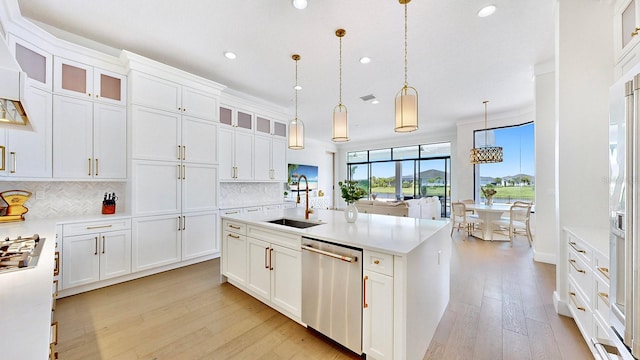 kitchen with dishwasher, sink, white cabinetry, and hanging light fixtures