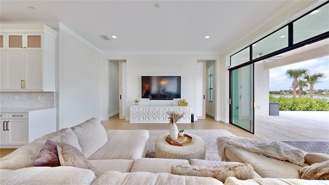 living room with crown molding and light hardwood / wood-style flooring