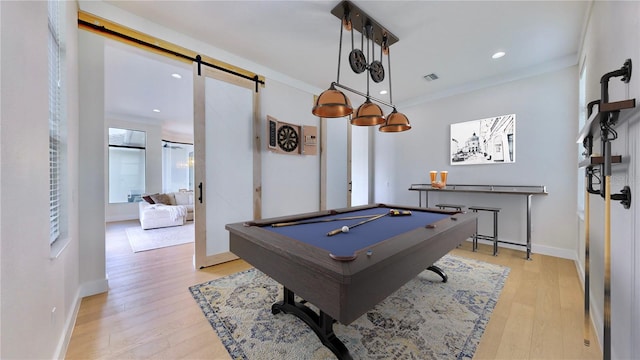 rec room featuring a barn door, billiards, light hardwood / wood-style floors, and ornamental molding