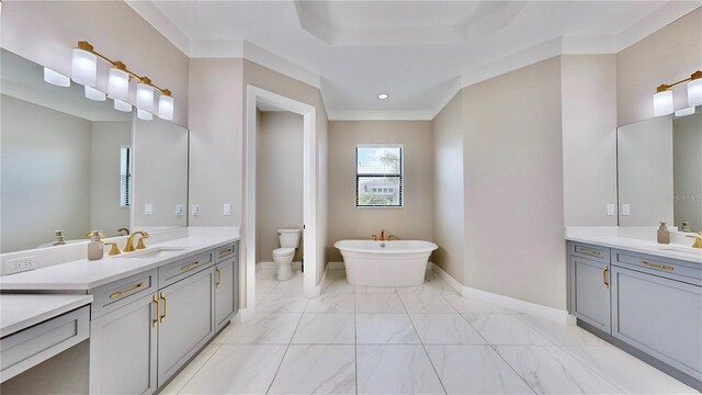 bathroom with vanity, toilet, a bath, and crown molding