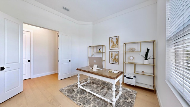 office space with light wood-type flooring and ornamental molding