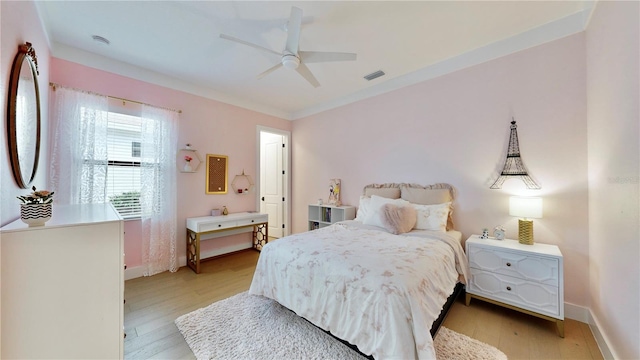 bedroom with ceiling fan, crown molding, and light hardwood / wood-style flooring