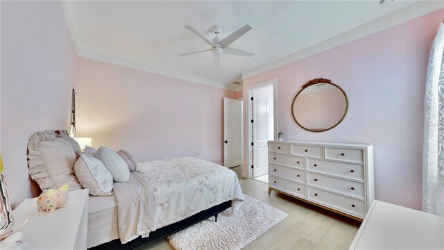 bedroom featuring light wood-type flooring, ceiling fan, and ornamental molding