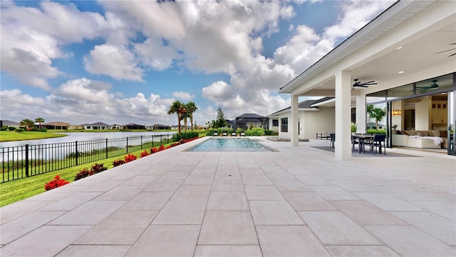 view of swimming pool featuring a patio area, ceiling fan, and a water view