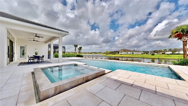 view of swimming pool with ceiling fan, a patio area, an in ground hot tub, and a water view