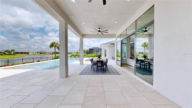 view of pool with a water view, ceiling fan, and a patio area