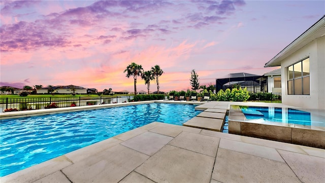 pool at dusk featuring fence, a fenced in pool, and a patio