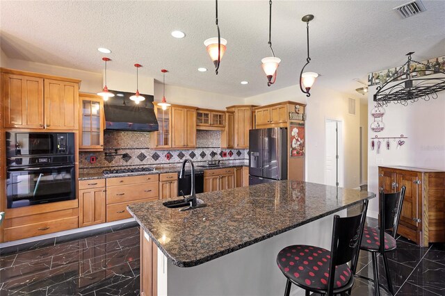 kitchen featuring decorative light fixtures, sink, a breakfast bar, and black appliances