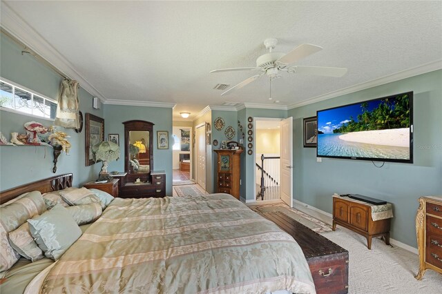 bedroom featuring crown molding, ceiling fan, light carpet, and a textured ceiling