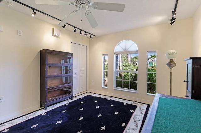 entryway with ceiling fan, track lighting, and a textured ceiling