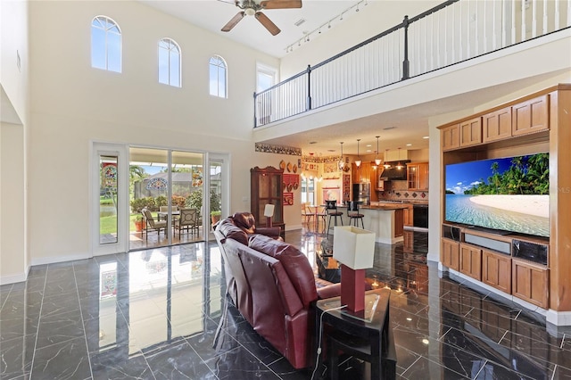 8607 51st Ave W, Bradenton, FL 34210 - living room with ceiling fan, a high ceiling, baseboards, and dark marble finish flooring