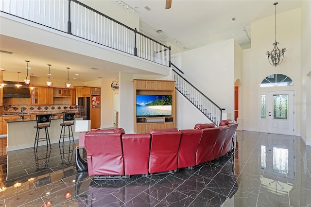 8607 51st Ave W, Bradenton, FL 34210 - living area featuring a high ceiling, dark marble finish floors, stairs, and arched walkways