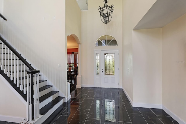 8607 51st Ave W, Bradenton, FL 34210 - entrance foyer featuring arched walkways, marble tiled floors, baseboards, a towering ceiling, and stairs