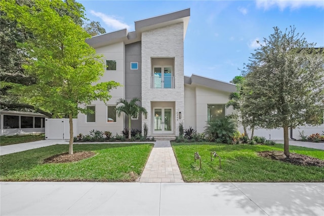 contemporary home featuring a front lawn and french doors