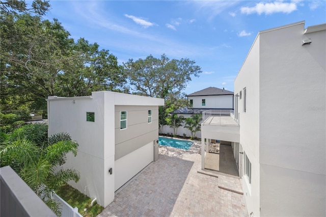 exterior space with a balcony and a fenced in pool