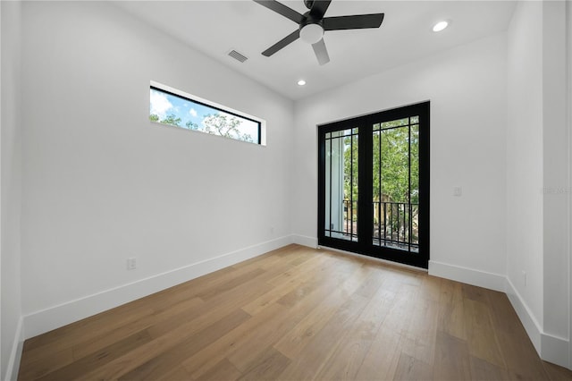 spare room with ceiling fan, a healthy amount of sunlight, and light hardwood / wood-style floors