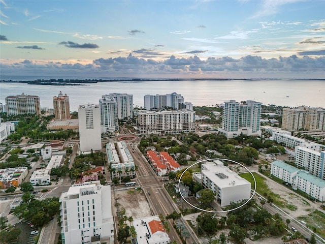 aerial view at dusk featuring a water view