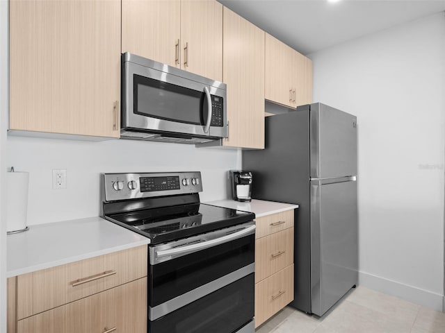 kitchen featuring light brown cabinets, light tile patterned floors, and appliances with stainless steel finishes