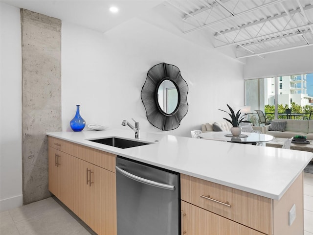 kitchen with stainless steel dishwasher, light brown cabinets, kitchen peninsula, and sink